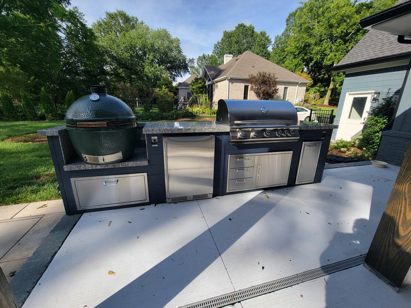 Modern white outdoor kitchen under covered patio with built-in grill and stainless storage