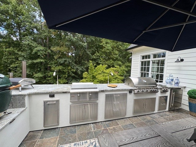 Modern outdoor kitchen with full-length grill station, prep space, and stainless doors